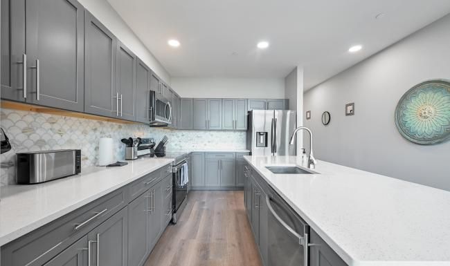 a large kitchen with dark cabinets and an island
